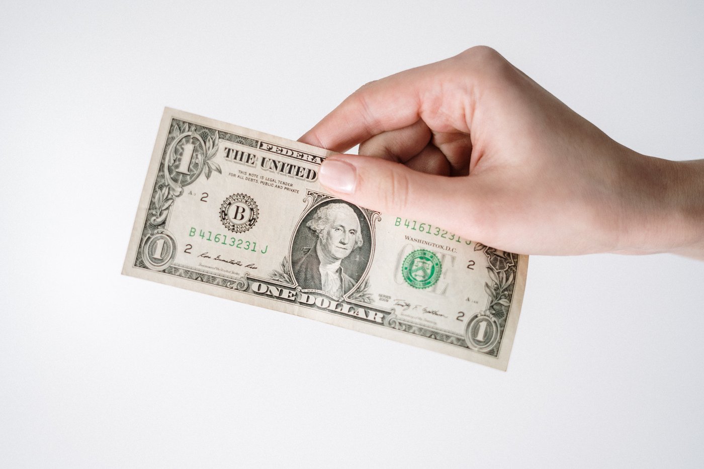 Hand holding a US dollar bill before exchanging it for Korean won